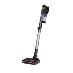 A cordless stick vacuum cleaner with a silver and black body, featuring a transparent dust bin and red accent details on the floor head, shown against a plain white background.