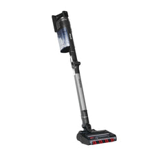 A cordless stick vacuum cleaner with a transparent dust bin, gray and black handle, and a black floor head with red accents, shown on a plain white background.